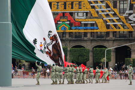 Mexico City, Mexico - Sep 6 2023: Military lower the monumetal Mexican flag from the flagpole in the CDMX zocalo in a ceremony with drums, trumpets and a parade of soldiersのeditorial素材