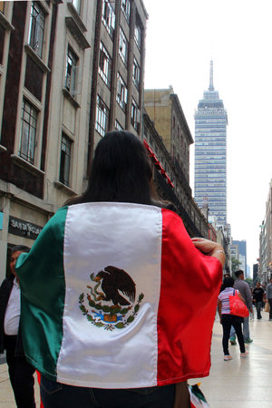 Mexico City, Mexico - Sep 6 2023: Woman proudly raises the Mexican flag on the Madero walker in the Îocalo of CDMX to celebrate Independence and Revolutionのeditorial素材