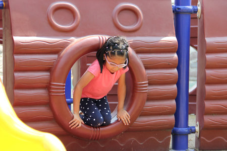 5 year old Latin brunette girl plays in the park playground away from the children in solitude...
