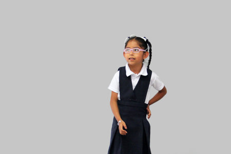 4 year old Latina brunette girl with glasses, braids and school uniform is ready and excited for...