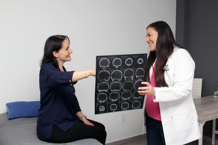 Female neurologist doctor shows the skull x-ray to a 40-year-old patient due to pain due to a blow...