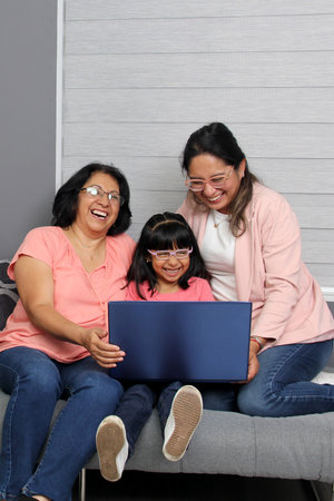 Three generations brunette latina grandmother, mom and daughter with glasses are surprised and...