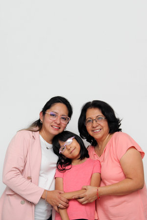 Brunette Latina grandmother, mom and daughter with glasses show their love and support together and...