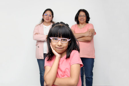 5-year-old Latin girl has the support of her dark-skinned mother and grandmother with glasses for...