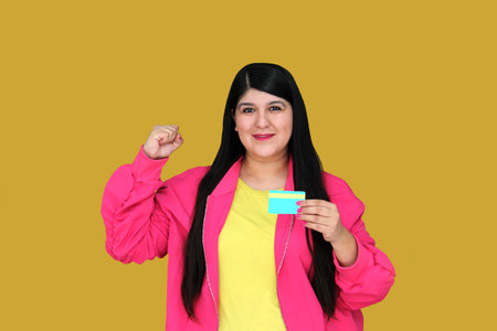 30 year old woman excitedly shows credit card ready to buy with discounts and promotionsの写真素材