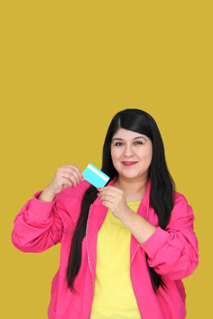 30 year old Latina woman excitedly shows credit card ready to buy with discounts and promotionsの写真素材