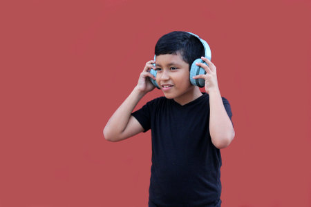 9-year-old brown Latino boy with sound-isolating headphones for autism spectrum disorder, ADHD and sensitivity to loud noisesの写真素材