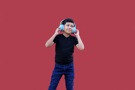9-year-old brown Latino boy with sound-isolating headphones for autism spectrum disorder, ADHD and...