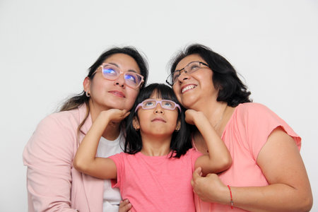 Family of grandmother, mother and daughter see with surprise and enthusiasm promotions and discounts that they are excited to buyの写真素材