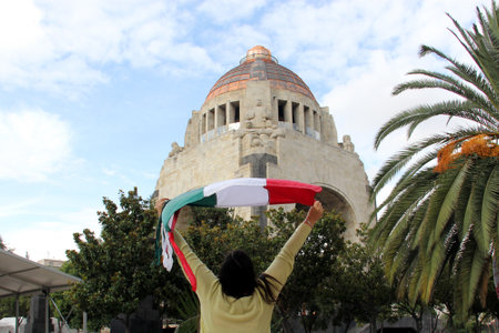 Latina adult woman shows the flag of Mexico with pride to celebrate the national holidays of Mexican Independence Day and Cinco de Mayoの写真素材