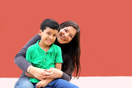 Single mom and dark-haired Latino son play and have fun together spending quality family timeの写真素材