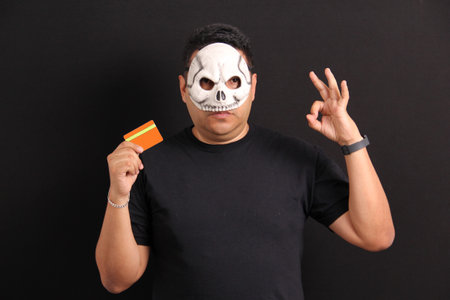 Mexican adult man with catrin mask to celebrate Day of the Dead in Mexico with credit card to buy...