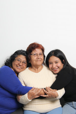 Three generations of brown Latina women, grandmother, mom and daughter show their love and support to celebrate Mother's Dayの写真素材