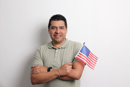 40-year-old dark-skinned Latino man shows the flag of the United States who lives as an immigrant in...