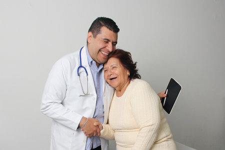 Elderly 80-year-old Latin woman visits the dark-skinned geriatric specialist medical doctor to check...