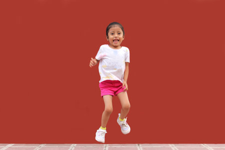 3-year-old brunette girl jumps with happiness, plays and has fun