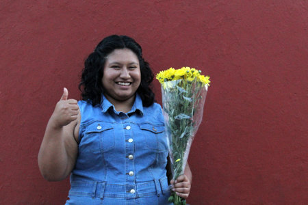 Young 20 year old brunette Latina woman shows her yellow flowers to welcome spring and loveのeditorial素材