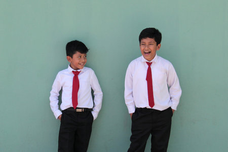 8 and 10 year old Latino children dressed in school uniforms are happy and excited about going back to schoolの写真素材