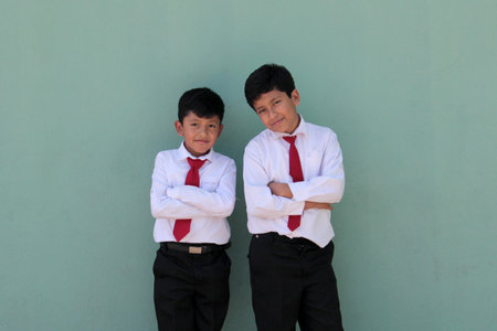 8 and 10 year old Latino children dressed in school uniforms are happy and excited about going back to schoolの写真素材