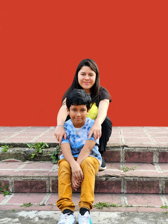 A 13-year-old Latina girl and a 10-year-old dark-skinned boy play and show their sibling and friend...
