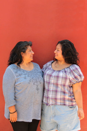 Divorced single mom and 20-year-old Latina daughter are happy to spend time together celebrating...