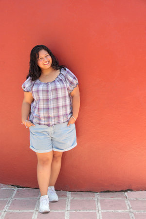 25-year-old Latina brunette woman with curly hair shows herself happy, empowered, and excited to celebrate life, harmony, and tranquilityの写真素材