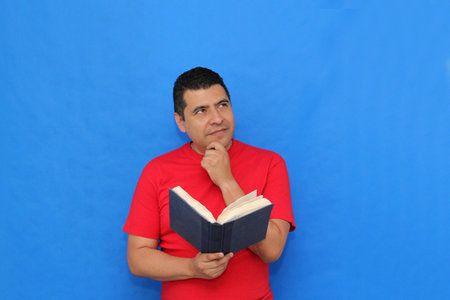 40-year-old dark-skinned Latino man reads and books and enjoys reading to learn, study, and gain...