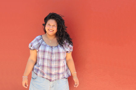 25-year-old brunette Latina woman with curly hair who studies and works appears happy, empowered, independent, and powerfulの写真素材