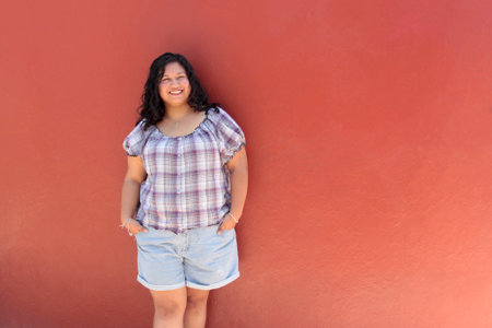 25-year-old brunette Latina woman with curly hair who studies and works appears happy, empowered,...