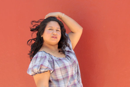 25-year-old Latina brunette woman with curly hair shows herself happy, empowered, successful, enjoying life and achieving her goalsの写真素材