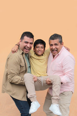 Three generations of a dark-skinned Latino grandfather, father, and son show their love and spend time together to celebrate Father's Dayの写真素材