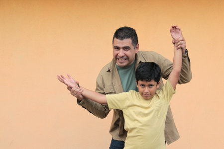 Single dad plays with his 10-year-old dark-skinned Latino son, spending time together to celebrate Father's Dayの写真素材