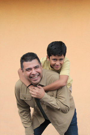 Single dad plays with his 10-year-old dark-skinned Latino son, spending time together to celebrate Father's Dayの写真素材