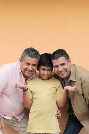 Three generations of a dark-skinned Latino grandfather, father, and son show their love and spend time together to celebrate Father's Dayの写真素材