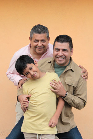 Three generations of a dark-skinned Latino grandfather, father, and son show their love and spend time together to celebrate Father's Dayの写真素材