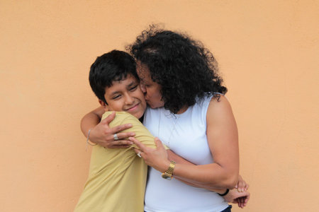 A single mother and her 9-year-old Latino son show their love with hugs and kisses to celebrate Mother's Dayの写真素材
