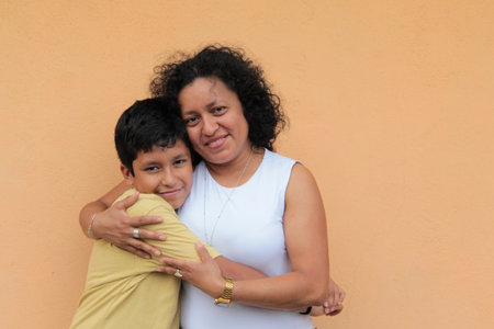 A single mother and her 9-year-old Latino son show their love with hugs and kisses to celebrate Mother's Dayの写真素材