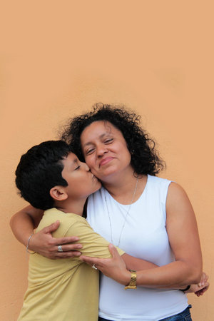 A single mother and her 9-year-old Latino son show their love with hugs and kisses to celebrate Mother's Dayの写真素材
