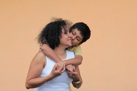 A single mother and her 9-year-old Latino son show their love with hugs and kisses to celebrate Mother's Dayの写真素材