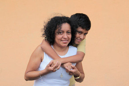 A divorced single mother and her 9-year-old Latino son show their love with hugs and kisses to celebrate Mother's Dayの写真素材