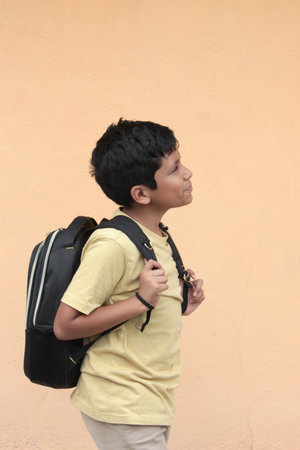 10-year-old Latino boy, excited and happy, uses his backpack with books to study and learn back to...