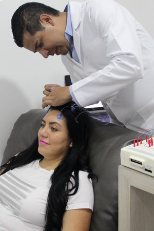 Electroencephalogram, a neurological study of an adult Latina woman with wires on her head to...