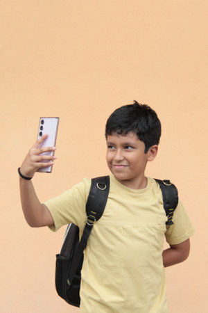 A 10-year-old boy uses his cell phone to play video games, make video calls, send messages, and take...