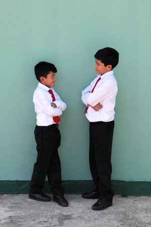 Two Latino boys, elementary school students in uniform, ready for back to school, excited and happyの写真素材