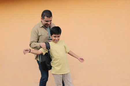 Divorced single dad helps his 10-year-old Latino son with his backpack for back-to-school studiesの写真素材
