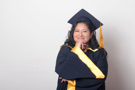 Young woman dressed in cap and gown celebrates her prom and appears pensive and thoughtful