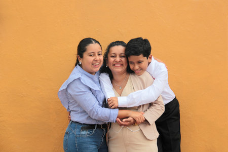 Dark-skinned mother, daughter, and son show their love with hugs and celebrate Mother's Day with their familyの写真素材