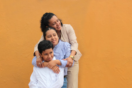 Dark-skinned Latino mother, daughter, and son show their love with hugs and celebrate Mother's Day...