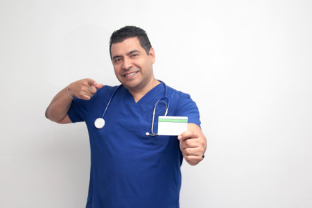 Dark-skinned Latino male doctor specialist shows credit or debit card to payの写真素材