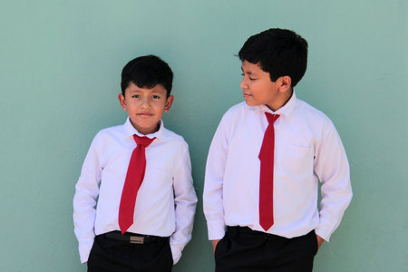8 and 10 year old Latino children dressed in school uniforms are happy and excited about going back to schoolの写真素材